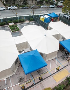 An aerial image of white and blue medical tents in the Salinas Valley Memorial Healthcare System parking lot.