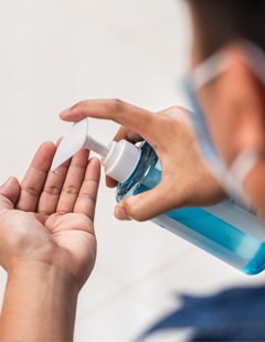 A hospital staff member uses hand sanitizer.